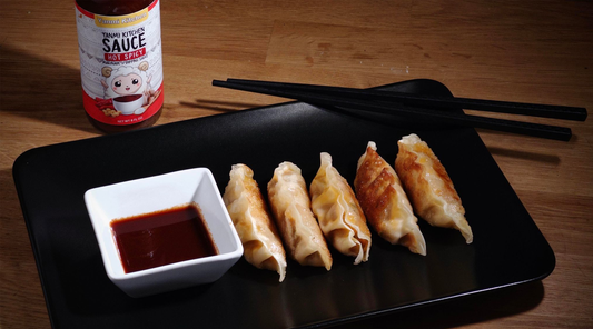 Pan-fried dumplings served with Yanmi Kitchen Sauce Hot-Spicy Sauce on the side